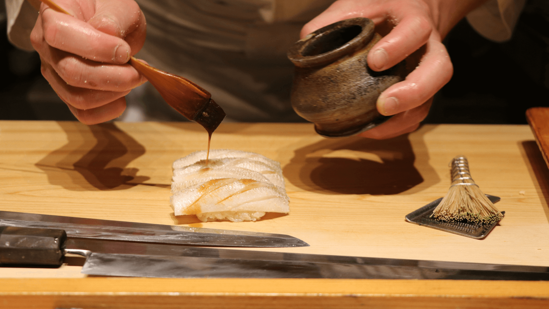 Serving the guest by pouring soy sauce to sashimi